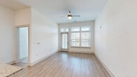 Located at 112 Hera Way in Myrtle Beach, SC, this well-designed 2-bedroom, 2-bathroom residence offers a bright and functional single-floor layout. The open-concept living and kitchen area serves as the heart of the home, featuring light wood-look flooring, crisp white walls, and soaring ceilings that amplify the sense of space. A wall of windows with transom panels and a private access door floods the living room with natural light, while a ceiling fan adds comfort. The kitchen is outfitted with soft gray cabinetry, stainless steel appliances including a range and built-in microwave, a herringbone tile backsplash, and a granite-topped peninsula with pendant lighting — ideal for casual dining or entertaining. The primary bedroom is generously sized, carpeted for warmth, and includes a walk-in closet with built-in wire shelving. The primary bath features a dual-sink granite vanity, light wood flooring, and a glass-enclosed walk-in shower. The second bedroom mirrors the bright, airy feel found throughout the home. Two closets provide ample storage. Clean, modern finishes and a neutral palette create a cohesive, move-in ready environment throughout the entire space.