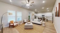 Located at 801 Jacquelyne Dr in Anna, TX, this two-story home offers 4 bedrooms, 4 bathrooms, a dedicated office, and a thoughtfully designed layout across two floors. The main floor provides the majority of the living space, featuring an inviting entryway with light hardwood-style flooring that flows seamlessly throughout. The open-concept kitchen and living area serves as the heart of the home, showcasing a bright, airy atmosphere with recessed lighting and ceiling fans. The kitchen is appointed with crisp white shaker cabinetry, a subway tile backsplash, stainless steel appliances, and a white quartz island with bar seating. A second living area upstairs offers additional flexible space. The office stands out with a bold navy accent wall, providing a stylish and functional work-from-home environment. The bedrooms are comfortably sized, including a primary bedroom with vaulted ceilings and natural light. The bathrooms are finished with marble-style tile flooring, white vanities, and glass-enclosed showers. Six closets, a pantry, a laundry room, and two entrances add to the home's practicality. The clean, neutral palette and modern finishes create a cohesive and welcoming atmosphere throughout.