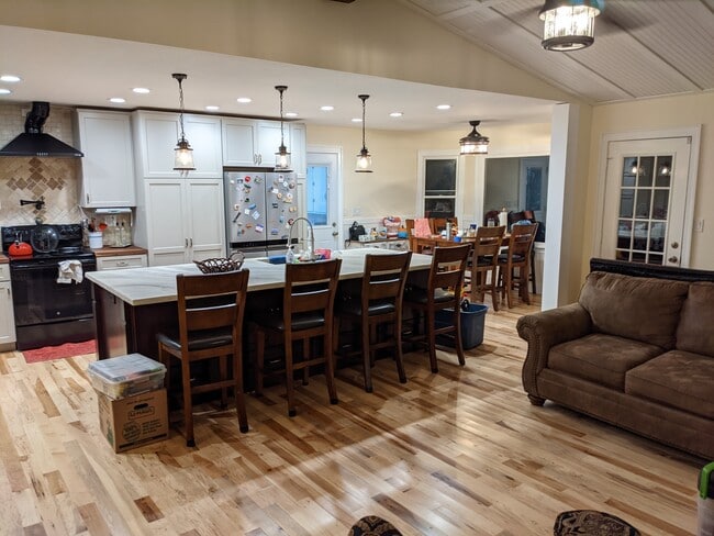 Open floor plan with spacious island, living room area with vaulted ceiling and kitchen dining area - 103 Wingfield Dr