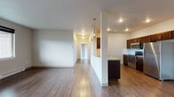 Located at 16511 East Sprague Avenue in Spokane Valley, WA, Unit F7 is a thoughtfully designed single-floor residence featuring a clean, contemporary aesthetic throughout. The open-concept living area is anchored by rich hardwood-style flooring that extends through the main living and kitchen spaces, while large windows and a glass exterior door invite natural light and provide views of the surrounding area. A wall-mounted A/C unit and baseboard heating ensure year-round comfort.

The kitchen is well-appointed with dark espresso cabinetry, stainless steel appliances including a refrigerator, electric range, and built-in microwave, along with a double sink and ample counter space. A peninsula with pendant lighting separates the kitchen from the living area, creating a natural and functional flow.

The bedrooms are carpeted for warmth and comfort, each offering generous proportions and access to natural light. The unit includes two full bathrooms — one featuring tile flooring and a tub/shower combination, and the other with wood-style flooring, a dark-toned vanity with mosaic tile backsplash, and a tub/shower. A central hallway connects the private and shared spaces efficiently, completing this functional and attractive residential unit.