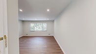This well-appointed three-bedroom, two-bathroom residence in Morristown, NJ offers a clean, modern aesthetic across a single thoughtfully designed floor. Warm wood-look flooring runs consistently throughout the home, creating a cohesive and inviting atmosphere in every room.

The open living area is bright and airy, featuring recessed lighting and neutral walls that maximize the sense of space. It flows seamlessly into the kitchen, which stands out as a highlight of the home. The kitchen is outfitted with crisp white shaker-style cabinetry, classic subway tile backsplash, light quartz countertops, and a full suite of stainless steel appliances including a refrigerator, range, microwave, and dishwasher.

The spacious primary bedroom benefits from natural light through a wide window framing greenery views, complemented by recessed lighting overhead. Two additional bedrooms offer comfortable proportions, each with windows providing natural light and ample wall space for flexible use.

The two bathrooms are finished in a clean, contemporary style. One features a white vanity with under-cabinet storage, a framed mirror, and a tiled shower, while the second includes a full tub-shower combination with white tile surround and modern fixtures. Both bathrooms continue the home's consistent wood-look flooring. Overall, the residence presents a fresh, move-in-ready environment with a neutral palette throughout.
