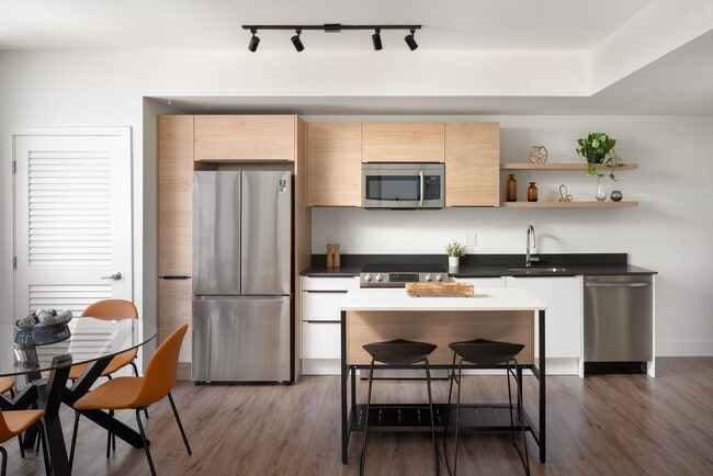 Las cocinas cuentan con encimeras de granito y modernos electrodomésticos Samsung. - Core Link at Douglas