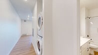 This studio unit at 62nd Ave S in Fargo, North Dakota, offers a thoughtfully designed, single-floor layout that makes efficient use of its compact footprint. The open living area is anchored by warm, light-toned hardwood-style flooring that runs continuously throughout the space, lending a clean and cohesive aesthetic.

The kitchen is a standout feature, outfitted with crisp white shaker-style cabinetry, light countertops, and a full suite of stainless steel appliances — including a range, over-the-range microwave, dishwasher, and a French door refrigerator. A double-basin stainless steel sink with a modern brushed nickel faucet sits beneath upper cabinets, maximizing storage and functionality.

The main living area is bright and open, with white walls and recessed lighting creating a fresh, airy atmosphere. A centrally positioned wall divides the space to incorporate a stacked in-unit washer and dryer, a practical amenity that adds considerable convenience.

The full bathroom features a white vanity with storage, a toilet, and a full tub-shower combination, all finished in a clean, minimalist style with matte black hardware accents and the same hardwood-style flooring. The unit's overall design is modern, neutral, and move-in ready, ideal for those seeking a well-appointed, low-maintenance living space in Fargo.