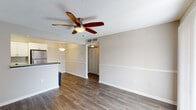 This single-floor residence offers a thoughtfully designed layout that balances functionality and comfort throughout its living spaces. The open-concept living and dining area serves as the heart of the home, finished with rich hardwood-style flooring and neutral-toned walls that create a bright, welcoming atmosphere. A ceiling fan with a light fixture adds both style and practicality to the space, while a chair rail detail along the walls contributes a classic architectural touch.

The kitchen is a standout feature, outfitted with crisp white cabinetry, dark charcoal countertops, and a classic subway tile backsplash that adds timeless character. A full suite of stainless steel appliances — including a refrigerator, range, built-in microwave, and dishwasher — ensures modern convenience. A peninsula counter connects the kitchen to the living area, making the space ideal for both cooking and entertaining.

The bedroom is generously sized, featuring plush wall-to-wall carpeting, a ceiling fan, and a window fitted with blinds that allows for natural light while maintaining privacy. The bathroom includes a full-size soaking tub with an overhead shower and clean white tile surround, offering a simple and functional retreat. Throughout the residence, the consistent use of neutral finishes and practical fixtures creates a cohesive and move-in-ready environment.