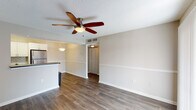 This single-floor residence offers a thoughtfully designed layout that balances functionality and comfort throughout its living spaces. The open-concept living and dining area serves as the heart of the home, finished with rich hardwood-style flooring and neutral-toned walls that create a bright, welcoming atmosphere. A ceiling fan with a light fixture adds both style and practicality to the space, while a chair rail detail along the walls contributes a classic architectural touch.

The kitchen is a standout feature, outfitted with crisp white cabinetry, dark charcoal countertops, and a classic subway tile backsplash that adds timeless character. A full suite of stainless steel appliances — including a refrigerator, range, built-in microwave, and dishwasher — ensures modern convenience. A peninsula counter connects the kitchen to the living area, making the space ideal for both cooking and entertaining.

The bedroom is generously sized, featuring plush wall-to-wall carpeting, a ceiling fan, and a window fitted with blinds that allows for natural light while maintaining privacy. The bathroom includes a full-size soaking tub with an overhead shower and clean white tile surround, offering a simple and functional retreat. Throughout the residence, the consistent use of neutral finishes and practical fixtures creates a cohesive and move-in-ready environment.