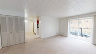 Located at 72 S Fremont Ave in Bellevue, PA, this one-bedroom, one-bathroom unit offers a practical and comfortable single-floor layout. The living area is generously proportioned, featuring neutral carpet flooring, a textured tile ceiling, and a large sliding glass door fitted with vertical blinds that fills the space with natural light and provides views of the surrounding neighborhood. A wall-mounted air conditioning unit and baseboard heating ensure year-round climate control.

The primary bedroom is notably spacious, accommodating a large furniture arrangement with ease. It features the same carpet flooring, a rich wood-toned entry door, and a built-in closet with louvered bifold doors for ample storage.

The galley-style kitchen is well-appointed with warm wood cabinetry lining both walls, butcher-block-style countertops, a double basin sink, electric coil range, dishwasher, and a full-size refrigerator. A window at the end of the kitchen brings in natural light, and light vinyl flooring completes the functional space.

The bathroom includes a tub-shower combination with a window for ventilation, accented by classic pink tile detailing. The unit's clean white walls and consistent finishes throughout create a cohesive, easy-to-personalize living environment.