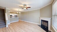 Located at 10 Fieldstone Common in Tolland, Connecticut, this well-appointed 2-bedroom, 3-bathroom home is thoughtfully laid out across three floors. The ground level features an attached garage with an epoxy-coated floor and automatic opener, along with a utility room and convenient bathroom. The main living floor showcases an open-concept kitchen and living room combination finished with light hardwood-style flooring, crown molding, and a classic fireplace framed by a white mantel. The kitchen is equipped with white shaker cabinetry, a stainless steel dishwasher, white quartz countertops, and a tile backsplash, while the living area benefits from natural light through large windows and a ceiling fan overhead. The upper floor is home to two generously sized bedrooms, each carpeted and fitted with ceiling fans and crown molding. The expansive primary bedroom offers abundant natural light through dual windows. A dedicated walk-in closet with wire shelving provides ample storage. Three bathrooms serve the home, including a full bath with a soaking tub and tiled surround, and a stylish vanity bathroom featuring shaker-style cabinetry with black hardware, quartz countertops, and warm vanity lighting. Neutral taupe tones and clean white trim carry a cohesive, modern aesthetic throughout.