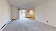 Located at 2555 Old Trevose Rd in Feasterville Trevose, PA, this one-bedroom, one-bathroom unit offers a practical and well-organized single-floor layout. The open kitchen and living area serves as the heart of the home, with the kitchen featuring warm oak cabinetry, recessed lighting, tile flooring, and black appliances including a refrigerator, range, and dishwasher. The living room extends comfortably from the kitchen, finished with neutral carpet, baseboard heating, and a sliding glass door that opens to an outdoor view, allowing natural light to fill the space. A wall-mounted AC unit provides additional climate control. The bedroom is a generously sized, sun-filled room with plush carpeting, a window for natural light, and an expansive dual bi-fold closet offering ample storage. The full bathroom is finished with white tile walls, large-format tile flooring, a wood-toned vanity with countertop sink, a lighted mirror, and a glass-enclosed shower stall. A connecting hallway ties the rooms together efficiently. Textured ceilings and clean white walls are consistent throughout, giving the space a bright, neutral aesthetic suitable for a variety of furnishing styles.
