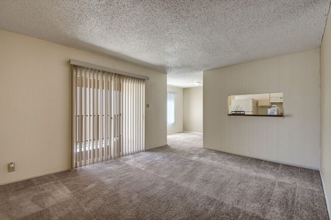 Una gran sala de estar con puertas corredizas de vidrio que dan al patio y fácil acceso a la cocina. - Fairgreen