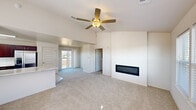Located on E 121st St S in Broken Arrow, Oklahoma, this two-story home offers two bedrooms, one bathroom, and a thoughtfully designed layout spread across two floors. The lower level is anchored by an open-concept kitchen and living room, where vaulted ceilings soar overhead and a ceiling fan adds comfort to the airy space. A sleek, linear built-in fireplace serves as a striking focal point on a clean white accent wall, while sliding glass doors invite natural light and provide access to an outdoor balcony area. The kitchen is well-equipped with rich dark wood cabinetry, marble-style countertops, stainless steel appliances including a range, microwave, and dishwasher, and a skylight that brightens the space. The upper floor houses the generously sized primary bedroom and a second bedroom, both featuring plush carpeting and windows that bring in natural light. The full bathroom includes a marble-topped vanity with dark wood cabinetry, a soaking tub, and tiled flooring. Closet storage is ample, with built-in wire shelving systems offering organized, flexible storage solutions throughout.