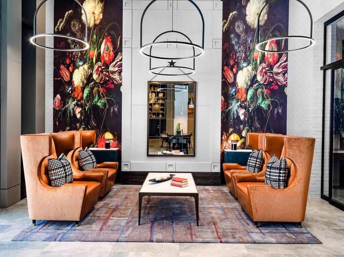 Vestíbulo con grandes sillas y espejo. - Verso Founders Row
