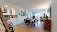 Located at 22520 Lyons Ave in Santa Clarita, CA, this well-appointed single-floor residence offers a thoughtfully designed open-concept layout with light hardwood flooring throughout the main living areas. The combined dining and living space is bright and airy, bathed in natural light from large sliding glass doors that lead to a private balcony with outdoor views of the surrounding Santa Clarita landscape.

The kitchen is a standout feature, boasting white shaker cabinetry, grey subway tile backsplash, quartz countertops, and a full suite of stainless steel appliances including a French door refrigerator, electric range, and over-the-range microwave. Recessed lighting adds a polished, modern touch.

The bedroom is generously sized with plush carpet flooring and multiple large windows fitted with plantation-style blinds, filling the room with natural light while offering views of the neighborhood.

A dedicated laundry area houses a stacked washer and dryer unit, adding everyday convenience. The clean, neutral color palette throughout the space creates a calm and cohesive ambiance, making this residence a comfortable and functional home in the heart of Santa Clarita.