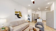 This well-appointed single-story residence in Gonzales, Louisiana, offers two bedrooms and two full bathrooms within a thoughtfully designed open-concept floor plan. Light wood-style flooring flows throughout the main living areas, complementing the crisp white walls and recessed lighting that create a bright, clean aesthetic.

The kitchen serves as a functional centerpiece, featuring white shaker-style cabinetry, granite countertops, a stainless steel appliance suite including a refrigerator, range, and microwave, and a subway tile backsplash. A large island with an undermount sink provides seating for multiple bar stools and connects seamlessly to the living area. Ceiling fans with recessed lighting enhance the open living space, which benefits from natural light through sizable windows.

Both bedrooms are generously sized with ample natural light. The primary bedroom includes access to a full bathroom with granite countertops, white cabinetry, and a walk-in closet with built-in shelving. The second bathroom mirrors the same refined finishes. Additional open shelving and well-distributed storage throughout the unit contribute to its practical, modern design.