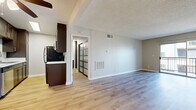 Located in the Chatsworth neighborhood of Los Angeles, this single-floor residence offers a thoughtfully designed layout that maximizes comfort and functionality. Light-toned luxury vinyl plank flooring runs throughout the space, complementing neutral-toned walls and textured ceilings to create a clean, modern aesthetic.

The open-concept kitchen and living area forms the heart of the home. The galley-style kitchen is outfitted with rich dark espresso cabinetry, white countertops, and a full suite of black and stainless steel appliances, including a refrigerator, range, microwave, and dishwasher. This kitchen flows naturally into the spacious living area, which features a sliding glass door that opens onto a private balcony overlooking a landscaped courtyard.

The generously sized primary bedroom provides a serene retreat, featuring a striking sliding barn-style door with frosted glass panels, a dedicated closet with dark wood cabinetry, and a window that allows natural light to fill the room. An adjacent entrance area offers a welcoming transition into the home.

The unit is equipped with central HVAC vents throughout, ensuring year-round climate comfort. The overall design strikes a balance between contemporary finishes and practical livability, making this a functional and inviting space in the heart of Los Angeles.