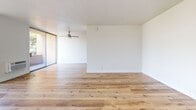 Located at 980 S Menlo Ave in Los Angeles, this thoughtfully designed one-bedroom, one-bathroom unit offers a clean, modern aesthetic throughout its well-proportioned single-floor layout. Warm wood-look flooring runs continuously across all rooms, creating a cohesive and inviting atmosphere.

The open-plan living room is bright and airy, featuring a ceiling fan and large sliding glass doors that lead to a private balcony with outdoor views — filling the space with natural light. The galley-style kitchen is well-appointed with gray shaker cabinetry, white quartz countertops, a white subway tile backsplash, and a full suite of stainless steel appliances including a range, microwave, refrigerator, and dishwasher.

The bedroom is a comfortable retreat, also equipped with a ceiling fan, and connects to a dedicated closet for ample storage. The bathroom is elegantly finished with marble-look tile surrounding a full soaking tub and shower combination, complemented by a gray vanity with a white countertop and brushed nickel fixtures. Clean white walls throughout the unit enhance the bright, contemporary feel of the space.