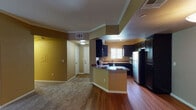This single-floor residence offers a thoughtfully designed layout with a seamless flow between living and functional spaces. The kitchen is a standout feature, showcasing rich dark wood cabinetry that extends from floor to ceiling, granite-style countertops, stainless steel appliances including a refrigerator and gas range, and a built-in microwave. A peninsula with bar seating connects the kitchen to the adjacent living area, making it ideal for entertaining. Wood-look flooring runs throughout the kitchen and entry areas, while plush carpet covers the main living and bedroom spaces.

The spacious living room is highlighted by a tiled fireplace, crown molding, and a sliding glass door that opens to an outdoor patio, allowing for an abundance of natural light. The warm tan wall tones create a cohesive and inviting ambiance throughout the home.

The bathrooms are well-equipped: one features a granite-topped vanity with dark cabinetry and a soaking tub with tiled surround, while the second offers a stand-up glass-enclosed shower and matching granite vanity. Both bathrooms echo the consistent design language found throughout the space. A dedicated entry foyer with wood-look flooring provides a welcoming transition into the home.