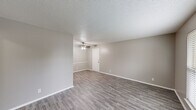 Located at 4001 Old Bullard Rd in Tyler, TX, this single-floor, one-bedroom, one-bathroom unit offers a well-organized layout designed to maximize comfort and functionality. Consistent wood-look flooring flows throughout the entire space, complemented by neutral gray-toned walls and white trim that create a clean, cohesive aesthetic. Textured ceilings add subtle character to each room.

The living room is a generous, open area equipped with a ceiling fan and light fixture, providing ample space for a variety of furniture arrangements. Natural light filters in through a large window fitted with blinds, offering a view of the surrounding greenery. A built-in shelving unit with cabinet storage adds a practical and decorative element to this room, which connects via a hallway to the rest of the unit.

The kitchen features white cabinetry, speckled quartz-style countertops, a built-in range, and a sink — all efficiently arranged to make the most of the available space. Two closets provide generous storage throughout the unit.

The bedroom is a well-sized, private retreat with its own window that allows in natural light. The full bathroom includes a tub and shower combination with tile surround, brushed nickel grab bar, and a vanity with matching countertop. A hallway connects the main living areas, ensuring a smooth flow throughout this thoughtfully laid-out home.