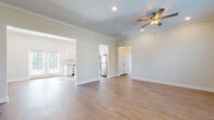Located at 252 Fife Way in Myrtle Beach, SC, this single-floor home presents a clean, modern aesthetic defined by neutral tones, crown molding, and warm hardwood-style flooring that flows throughout the main living areas. The open-concept layout connects a generously sized living room to the kitchen, creating a seamless flow ideal for everyday living and entertaining. Ceiling fans with integrated lighting and recessed fixtures provide well-distributed illumination, while multiple windows dressed with blinds invite abundant natural light.

The kitchen is a functional highlight, outfitted with white shaker-style cabinetry extending to the ceiling, granite countertops, a subway tile backsplash, and a full suite of stainless steel appliances including a refrigerator, range, microwave, and dishwasher. A granite-topped island with pendant lighting adds prep space and visual interest.

Bedrooms feature hardwood-style flooring, ceiling fans, and multiple windows that frame outdoor greenery. The primary bathroom offers a walk-in glass shower, a white vanity with granite countertop, and tile flooring. A secondary bathroom includes a tub-shower combination. A dedicated laundry area accommodates a full-size washer and dryer, completing this well-appointed home.