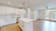 Located at 2219 Jack Ln in Bel Air, Maryland, this well-appointed 2-bedroom, 2-bathroom single-floor home offers a clean, modern aesthetic throughout. The open-concept kitchen and living area serves as the heart of the home, featuring white shaker cabinetry, quartz countertops, a center island with pendant lighting, and a full suite of stainless steel appliances including a gas range, microwave, and dishwasher. Light hardwood-style flooring flows throughout the main living areas, complementing the bright, neutral color palette. The living room is bathed in natural light and opens directly to the outdoors through French doors with transom windows, enhanced by a ceiling fan overhead. The primary bedroom offers generous proportions with plush carpeting, ample closet space, and an en-suite bathroom. The second bedroom also features carpeted flooring and large windows overlooking greenery, filling the room with natural light. Both bathrooms are finished with white cabinetry, quartz vanity tops, and tile flooring. Additional highlights include four closets providing abundant storage, a dedicated laundry area, and a cohesive modern design that maintains a bright and airy ambiance throughout.