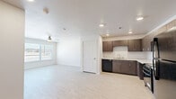 Located at 1202 Main St in Lubbock, TX, this single-story, 3-bedroom, 2-bathroom home delivers a clean and modern living experience with thoughtfully selected finishes throughout. The open-concept kitchen and living area serves as the heart of the home, featuring light marble-style tile flooring, recessed lighting, and a large bank of windows fitted with horizontal blinds that invite natural light and outdoor views. The kitchen is well-equipped with dark wood cabinetry, light stone countertops, and black appliances including a refrigerator, range, microwave, and dishwasher. The three bedrooms are carpeted in a neutral blue-grey tone, offering a comfortable and quiet retreat. Each room features white walls, ceiling fans with integrated lighting, and windows overlooking the outdoors. The spacious primary bedroom provides a generous personal space. The two bathrooms are finished with marble-style tile flooring and white fixtures; one includes a walk-in shower with grab bars, while the other features a full soaking tub with a shower rod. Clean white walls, modern hardware, and a vanity with dark cabinetry complete the bathrooms. A connecting hallway ties the layout together efficiently, making this home functional and move-in ready.