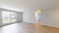Located at 93 Southpoint Dr in Amherst, MA, this single-floor unit offers three bedrooms, one bathroom, a living room, and a kitchen within a compact and efficiently designed layout. The living area features light-toned luxury vinyl plank flooring and neutral gray walls, with a large window allowing natural light and views of the surrounding greenery. Baseboard heating is present throughout. The galley-style kitchen is well-appointed with white cabinetry, marble-style countertops, a stainless steel sink, and stainless steel appliances including a dishwasher, range, and refrigerator. The full bathroom includes a tub/shower combo and wood-look vinyl flooring. The three bedrooms are carpeted and neutrally painted, each offering a quiet, functional space. The primary bedroom is generously sized and features two windows for natural light. Additional bedrooms include built-in closets and baseboard heating. An entry area provides access to a utility panel and storage. The overall aesthetic is clean and updated, making this a practical and move-in ready unit in the Amherst area.