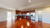 Located at 70 Michigan Ave W in Battle Creek, Michigan, this single-floor residence offers a thoughtfully designed layout across a generously sized footprint. Rich cherry-toned hardwood floors flow throughout the open living areas, creating a warm and cohesive aesthetic from room to room.

The kitchen is a standout feature, outfitted with an abundance of rich wood cabinetry, dark granite countertops, and a full suite of stainless steel appliances including a range, built-in microwave, dishwasher, and French door refrigerator. Recessed lighting above adds a polished, functional touch. The kitchen opens seamlessly into the living area, which benefits from natural light through multiple windows.

The spacious primary bedroom is carpeted for comfort and connects to a walk-in closet equipped with built-in shelving and hanging rods. The primary bathroom is well-appointed, featuring a soaking tub positioned beneath a window, a separate glass-enclosed shower, a wood vanity with granite countertop, and tile flooring. A second full bathroom serves the remainder of the unit. Neutral wall tones throughout lend a clean, move-in-ready feel to the entire space.