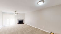 Located at 12919 Windfern Road in Houston, TX, this single-story 2-bedroom, 1-bathroom home offers a well-planned layout across a compact, efficient footprint. The living room serves as the heart of the home, highlighted by a tile-surround wood-burning fireplace, a ceiling fan with light fixture, and neutral carpet flooring that creates a warm, inviting atmosphere. Natural light filters in through sheer window treatments, adding brightness to the open space.

The galley-style kitchen is efficiently designed with white cabinetry, granite-look countertops, a stainless steel sink, and black appliances including a refrigerator, electric range, built-in microwave, and dishwasher. Wood-look vinyl plank flooring ties the kitchen together with a clean, modern aesthetic.

Both bedrooms feature plush carpet, ceiling fans, and ample wall space, with the primary bedroom offering a comfortable, well-proportioned layout. A hallway connects the bedrooms to the shared bathroom, which includes a shower/tub combo and wood-look vinyl flooring. The dedicated laundry area provides upper white cabinetry for storage alongside washer and dryer connections. A closet rounds out the home's functional storage options.