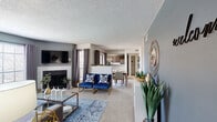 This single-story, 2-bedroom, 2-bathroom home delivers a thoughtfully designed layout that maximizes every square foot. The open-concept living area serves as the heart of the home, featuring a tiled fireplace, plush carpet flooring, and natural light streaming through multiple windows adorned with stylish gray drape panels. The living space flows seamlessly into a dedicated dining area and into the kitchen beyond.

The kitchen is equipped with rich dark wood cabinetry, granite-look countertops, a white subway tile backsplash, wood-look flooring, and a full suite of stainless steel appliances including a refrigerator, range, and microwave.

The primary bedroom is a comfortable retreat with carpet flooring, a ceiling fan, natural light from a large window, and direct access to a dedicated closet. The second bedroom mirrors a similarly relaxed aesthetic with a ceiling fan and neutral tones. Both bathrooms are well-appointed, featuring wood-look flooring, dark vanity cabinetry, and tiled tub-shower combinations.

Additional highlights include a dedicated in-unit laundry room with full-size washer and dryer, two closets for ample storage, and a connecting hallway that ties all spaces together efficiently. The home's consistent cool-gray color palette and modern finishes create a cohesive and contemporary ambiance throughout.