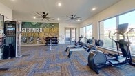 This well-designed single-floor residence offers a seamless blend of comfort and modern style. The open-concept layout connects the living room and kitchen, creating an inviting and functional space. The living area features light wood-style flooring, a ceiling fan, large windows that allow abundant natural light, and tasteful décor including framed artwork and a neutral sofa accented with bold blue throw pillows.

The kitchen is thoughtfully equipped with gray shaker-style cabinetry, granite countertops, a white subway tile backsplash, and stainless steel appliances including a refrigerator, electric range, and over-the-range microwave. A peninsula with a granite countertop and seating for three features pendant lighting overhead, making it ideal for casual dining or entertaining.

The bedroom is a serene retreat with large windows dressed in elegant drape panels, a ceiling fan, and ample space for a full dresser and bedside furnishings. The bathroom includes a soaking tub and shower combination with gray tile surround. A dedicated in-unit laundry area provides added convenience. Light wood-style flooring flows consistently throughout, unifying the space with a clean, contemporary aesthetic.