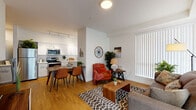 Located at 16708 East Broadway Avenue in Spokane Valley, WA, this single-floor unit offers a well-designed, contemporary living experience. The open-concept layout seamlessly connects the living, dining, and kitchen areas, all finished with warm hardwood-style flooring that enhances the bright, airy atmosphere. Large vertical-blind windows allow generous natural light to fill the living space, which also features a private exterior door for added convenience.

The kitchen is outfitted with crisp white shaker-style cabinetry, white countertops, stainless steel appliances — including a refrigerator, electric range, microwave, and dishwasher — and track lighting overhead, making it both functional and visually clean.

The bedrooms are carpeted for comfort and feature ceiling fans, large windows with vertical blinds, and ample space. The layout, as seen in the 3D model, includes multiple bedrooms served by well-appointed bathrooms. One bathroom features a white vanity with a large mirror and hardwood-style flooring, while another includes a shower-tub combination. Throughout the unit, the neutral white walls and consistent finishes create a cohesive, modern aesthetic suited for comfortable everyday living.
