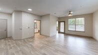 Located at 7116 Finn Hall Avenue in Charlotte, NC, this single-story, one-bedroom, one-bathroom residence offers a clean, modern design with consistent light wood-style flooring flowing throughout every room. The open living area is bright and airy, benefiting from large windows that invite natural light and a ceiling fan that adds comfort and functionality. A sliding glass door provides additional light and outdoor access directly from the living space.

The kitchen is well-equipped and thoughtfully designed, featuring gray shaker-style cabinetry, granite-look countertops, a subway tile backsplash, and a full suite of stainless steel appliances including a range, microwave, dishwasher, and refrigerator. Track lighting overhead ensures excellent task illumination throughout.

The bedroom is a comfortable, well-proportioned room with a ceiling fan, a large window overlooking greenery, and neutral wall tones that create a calm atmosphere. It connects directly to the bathroom, which includes a granite-topped vanity with white cabinetry and a mirror. Adjacent to the bathroom is a dedicated walk-in closet with built-in shelving and hanging rods, offering practical storage solutions. The overall aesthetic is modern, neutral, and move-in ready.