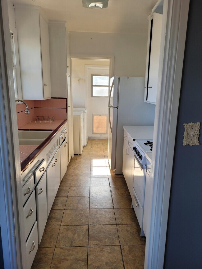kitchen w/ range/oven, refrigerator, washer & dryer leading to backyard - 900 Patterson Ave