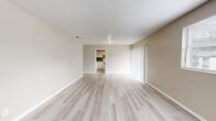 Located at 1591 Lane Ave in Jacksonville, FL, this single-story, 3-bedroom, 2-bathroom home offers a clean and functional layout designed for comfortable everyday living. The interior is finished with light-toned luxury vinyl plank flooring throughout the main living areas, complemented by neutral beige walls and white trim that create a bright, cohesive atmosphere.

The spacious living room serves as the heart of the home, featuring large windows that invite natural light and provide views of the surrounding neighborhood. It flows conveniently toward the kitchen, which is equipped with white cabinetry, a blue-gray tile backsplash, gray laminate countertops, a double-basin sink, a white electric range, and a dishwasher — offering ample storage and functionality.

The three bedrooms are well-proportioned, with the primary bedroom featuring its own closet. The bedrooms are carpeted for added comfort and each includes a window for natural light. Three closets throughout the home provide generous storage options, connected via two hallways for easy navigation.

The two bathrooms are finished with light vinyl flooring and white fixtures. One bathroom features a tub-shower combination with white tile surround, while the second offers a neo-angle glass-enclosed standing shower, each paired with a single vanity and mirror.