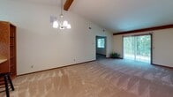 Located at 6837 Lake Forest Village Cir in Fort Wayne, Indiana, this single-story home offers a well-organized layout with a variety of functional spaces throughout. The living and dining areas are among the most striking features of the home, showcasing vaulted ceilings accented by exposed wooden beams that add architectural character and a sense of openness. A chandelier illuminates the dining area, while sliding glass doors and a front-facing window fill both spaces with natural light and provide views of the surrounding greenery.

The carpeted bedrooms are comfortably sized, each featuring ceiling fans with integrated lighting and windows that bring in natural light with pleasant outdoor views. The rooms share a neutral color palette with warm wood trim throughout.

The galley-style kitchen is equipped with oak cabinetry, a double sink, a cooktop range, a refrigerator, and a dishwasher. Light-toned flooring and a window contribute to a bright, practical workspace. A door leads from the kitchen to what appears to be an exterior or utility access point.

Two full bathrooms are present, each featuring a tub-shower combination, a wood-vanity with a light countertop, and tile-style flooring. Overall, the home presents a clean, neutral interior ready for personalization.