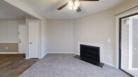 Located at 1620 Woods Rd in Winston-Salem, NC, this efficiently designed 2-bedroom, 1-bathroom single-story home offers a comfortable and functional layout. The combined kitchen and living room forms the heart of the space, where plush wall-to-wall carpeting, a ceiling fan with light fixture, and a classic white-mantled wood-burning fireplace create a warm and inviting atmosphere. A sliding glass door opens to a private outdoor patio, allowing natural light to fill the room and providing pleasant outdoor views. The kitchen is well-appointed with white cabinetry, dark granite-style countertops that extend to a breakfast bar, black appliances including a refrigerator and range, and a built-in microwave, all complemented by easy-to-clean hard surface flooring. Both bedrooms are carpeted and include ceiling fans, with the primary bedroom offering a spacious closet featuring double sliding doors and built-in shelving and hanging rods. The full bathroom features wood-look flooring, a white vanity with dark countertop, a full tub-shower combination with grab bars, and pendant lighting. A hallway connects the private spaces, completing this practical and cozy home.