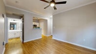 Located at 10809 Westwood Loop in San Antonio, TX, this 2-bedroom, 1-bathroom residence offers a practical and comfortable single-floor layout. Warm wood-look flooring runs throughout the space, lending a cohesive and inviting feel to every room.

The combined kitchen and living area forms the heart of the home. The kitchen is equipped with stainless steel appliances — including a refrigerator, electric range, and over-the-range microwave — alongside white cabinetry and light countertops that maximize the sense of brightness. A louvered pantry door adds a classic touch and functional storage.

The living room features neutral-toned walls, clean white baseboards, and a glass-paneled door that opens to a private balcony overlooking mature oak trees and the building's natural stone exterior — a charming outdoor retreat.

The primary bedroom is generously proportioned and filled with natural light from a large window, complemented by a ceiling fan with integrated lighting. The second bedroom also benefits from natural light and wood-look flooring. The bathroom is clean and straightforward, featuring a full tub-shower combination with white tile surround. Crown molding in the living and primary bedroom areas adds a refined architectural detail throughout.