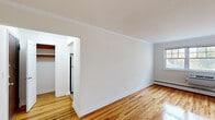 Located at 46 Jerseyville Ave in Freehold, NJ, this single-floor space offers a clean, well-maintained interior with consistent design details throughout. Warm hardwood flooring runs across the main living and bedroom areas, complemented by crisp white walls and crown molding that lend a classic, polished character to each room.

The layout, as seen in the floor plan, follows a functional, elongated configuration with clearly defined rooms. The living spaces feature baseboard heating and windows that allow natural light to filter in, creating a bright and airy atmosphere. A closet with built-in shelving provides practical storage in one of the rooms.

The kitchen is designed in a galley style, outfitted with white shaker cabinetry, stainless steel appliances including a refrigerator, gas range, and microwave, and light-toned vinyl plank flooring. A window at the end of the kitchen brings in natural light and outdoor views of surrounding greenery.

The bathroom features floor-to-ceiling white ceramic tile surrounding a full bathtub and shower combination. A window positioned above the tub offers natural light and a view of mature trees outside, enhancing the clean, classic aesthetic of the space. Overall, the unit presents a tidy, move-in-ready environment with timeless finishes throughout.