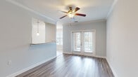 Located at 101 Tomshire Dr in Charleston, SC, this single-floor residence offers a well-designed layout with consistent, high-quality finishes throughout. The open living area is highlighted by durable hardwood-style flooring, elegant crown molding, and a ceiling fan with integrated lighting. French doors flood the space with natural light and provide direct access to an outdoor area, enhancing the bright and airy atmosphere.

The kitchen is a standout feature, showcasing rich dark-wood cabinetry extending to the ceiling, granite countertops, a breakfast bar peninsula with pendant lighting, and a full suite of stainless steel appliances including a refrigerator, range, and over-the-range microwave. Marble-style tile flooring in the kitchen adds a refined contrast to the living area's wood-look floors.

The bedroom is a generously sized, tranquil retreat with the same wood-style flooring and ample closet access. The bathroom continues the upscale aesthetic with dark cabinetry, granite countertops, a large mirror, and marble-style tile flooring. A dedicated laundry room with washer and dryer hookups, built-in wire shelving, and tile flooring adds everyday convenience. The neutral color palette throughout creates a cohesive, modern feel.