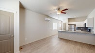 Located at 7596 Pitcher Pt in Fountain, Colorado, this efficiently designed single-floor unit offers a thoughtful layout that maximizes every square foot. Light wood-tone flooring runs throughout the space, complemented by crisp white walls that create a clean, bright atmosphere.

The main living area features a ceiling fan with a built-in light fixture and is bathed in natural light from multiple windows fitted with white horizontal blinds, offering views of the surrounding neighborhood. A wall-mounted PTAC unit provides climate control.

The kitchen is well-equipped with stainless steel appliances, including a range, over-the-range microwave, and dishwasher—all by Whirlpool. White cabinetry with granite-look countertops and a light gray subway tile backsplash give the kitchen a modern, polished look.

The bathroom features light wood-look flooring consistent with the rest of the unit, a white vanity with a granite-look countertop, a bathtub/shower combination, and a window for natural ventilation. The space also includes a dedicated closet, accessible via a charming arched-top gray door. Overall, the unit presents a clean, contemporary aesthetic with functional amenities suited for efficient, comfortable living.