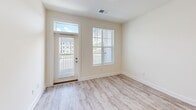 Located at 13300 Ardmore Valley Way in Knoxville, TN, this well-appointed one-bedroom, one-bathroom unit offers a thoughtfully designed single-floor layout. The open-concept kitchen and living area serves as the heart of the home, featuring light hardwood-style flooring throughout. The kitchen is outfitted with crisp white shaker cabinetry, a subway tile backsplash, granite countertops, a large peninsula with an undermount sink and modern pull-down faucet, and a full suite of stainless steel appliances including a gas range, built-in microwave, and refrigerator. Elegant pendant lighting above the peninsula adds a refined touch. The living area is bathed in natural light, with large windows and a glass-panel entry door offering outdoor views of the surrounding community. The spacious bedroom features plush wall-to-wall carpeting, a ceiling fan, and a sun-filled window. An adjacent walk-in closet provides generous storage with wire shelving systems. The bathroom connects conveniently to the closet and features light wood-look tile flooring. A dedicated laundry room with full-size washer and dryer and overhead wire shelving adds everyday practicality to this clean, modern Knoxville residence.