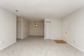 Located at 4150 Arkwright Rd in Macon, Georgia, this single-floor residence offers a thoughtfully laid-out interior with a warm, neutral palette throughout. The main living area is generously proportioned, featuring plush wall-to-wall carpeting, a classic wood-burning fireplace, and a ceiling fan overhead. Natural light flows in through multiple windows, creating a bright and welcoming ambiance. An open archway connects the living space to a dedicated dining area, which is accented by an elegant chandelier and chair-rail molding along the walls, adding a touch of traditional character.

The galley-style kitchen is outfitted with light wood cabinetry, white countertops, and wood-look vinyl flooring, providing a clean and functional workspace. The bedroom spaces are carpeted and well-sized, each with ceiling light fixtures and windows that bring in natural light. A standout feature is the spacious walk-in closet, complete with extensive wire shelving on multiple walls for generous storage. An additional closet provides further organizational options.

The full bathroom includes a single-sink vanity with wood cabinetry, tile flooring, and a shower-tub combination. The consistent use of soft tones and carpet throughout the home lends a cohesive and comfortable feel to the entire space.