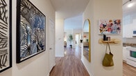 Located at 625 Cameron Walk Ct in Charlotte, NC, this thoughtfully designed 2-bedroom, 4-bathroom single-floor residence offers a comfortable and functional layout. A welcoming entryway with wood-look flooring leads into the open living and dining area, where crown molding, large sliding glass doors, and abundant natural light create an inviting atmosphere with outdoor access. The kitchen features a peninsula with granite-style countertops, white cabinetry, track lighting, and white appliances, making it both practical and visually clean. Two well-proportioned bedrooms are carpeted and filled with natural light from generously sized windows with blinds and curtains. The primary bedroom includes a spacious walk-in closet outfitted with multi-level wire shelving. Four bathrooms offer white tile tub-shower combinations and vanities with ample cabinet storage. A dedicated laundry room accommodates a full-size washer and dryer side by side on wood-look flooring. Two closets throughout the home provide additional storage. The overall design balances neutral tones with practical finishes, creating a bright and livable space suited for everyday comfort in the heart of Charlotte.