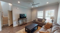 This two-story home offers a thoughtfully designed layout across two levels, combining functional living spaces with consistent, quality finishes throughout. The main level features a welcoming living room with dark hardwood-style flooring, crown molding, recessed lighting, and a ceiling fan. A staircase connects to the upper level, while an open passage leads to a dedicated dining area with built-in cabinetry and direct sightlines into the kitchen. The kitchen is well-equipped with white shaker-style cabinetry, granite countertops, stainless steel appliances, and hardwood-style flooring. An adjacent laundry room provides added convenience. The main level also includes a full bathroom with a tub-shower combination and brushed nickel fixtures.

Upstairs, two bedrooms offer comfortable retreats. The primary bedroom includes dark hardwood-style flooring, crown molding, recessed lighting, and an en-suite bathroom. The second bedroom features plush carpeting, a ceiling fan, and multiple windows for natural light. A generously sized walk-in closet with built-in shelving serves one of the bedrooms. The attached garage provides additional storage and parking, completing this well-organized home.