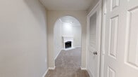This single-floor, 2-bedroom, 3-bathroom home offers a thoughtfully designed layout across a comfortable and functional floor plan. An elegant arched entryway leads into one of two living areas, where a classic white-mantled fireplace serves as a striking focal point, anchored by plush neutral carpeting throughout.

The kitchen is well-equipped with crisp white shaker-style cabinetry, granite countertops, a mosaic tile backsplash, wood-look flooring, and stainless steel appliances including a dishwasher. A window above the sink brings in natural light, adding to the room's bright, clean aesthetic.

The primary bedroom is a generously sized retreat featuring a ceiling fan and a natural light-filled window. The second living area offers crown molding, built-in shelving, and access to additional rooms via a louvered-door closet. The second bedroom also features crown molding and multiple windows fitted with horizontal blinds.

Three bathrooms serve the home, including one with a full tub-shower combo surrounded by classic white and beige tile, wood-look flooring, and overhead cabinetry. Another bathroom showcases a granite vanity countertop and a separate shower. A dedicated laundry closet with shelving, utility hookups, and wood-look flooring adds further practicality to this well-rounded home.