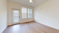 This 1,040-square-foot single-story residence in North Augusta, SC features 2 bedrooms, 2 bathrooms, and 3 closets, delivering a clean, modern aesthetic throughout. The open-concept kitchen and living area serves as the heart of the home, showcasing white shaker cabinetry, subway tile backsplash, quartz countertops, stainless steel appliances, and a large center island with pendant lighting — ideal for both cooking and entertaining. Light wood-style flooring runs continuously throughout the unit, enhancing the bright, cohesive feel. The living area is bathed in natural light through large windows with white horizontal blinds and features a private exterior door. The primary bedroom spans 160 square feet and includes a ceiling fan, generous natural light, and direct access to a well-appointed en-suite bathroom featuring a double-sink vanity with white cabinetry, black hardware accents, a walk-in glass shower with tile surround, and dual windows. The second bedroom also features a ceiling fan, ample natural light, and a closet. The second bathroom offers a single vanity, tub-shower combination with glass enclosure, and matching black hardware finishes. The consistent use of white walls, black matte fixtures, and warm flooring gives this home a polished, contemporary character.