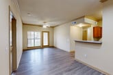 Located at 11900 Oakmoor Pkwy in Houston, TX, this single-floor, three-bedroom, two-bathroom home offers a functional and comfortable layout. The open-concept living area is a standout feature, showcasing wood-look laminate flooring, crown molding, and a ceiling fan that adds to the airy feel of the space. A large front-facing window and glass-panel door allow natural light to fill the room while providing outdoor views. The kitchen is positioned adjacent to the living area and features a peninsula with a countertop overhang, warm wood-toned cabinetry, black appliances including a refrigerator and microwave, and track lighting overhead. The bedrooms are carpeted for comfort and each includes a ceiling fan and window for natural light. The primary bedroom offers a dedicated closet and connects conveniently to the hallway. The bathrooms are finished with clean white tile surrounds and tub-shower combinations with warm wood-toned cabinetry above. A dedicated laundry room provides in-unit hookups and wire shelving for added storage. The hallway connects all rooms efficiently, and a closet provides additional storage space throughout this well-organized home.