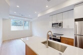 Located at 507 Kennedy St NW in Washington, DC, this thoughtfully designed single-floor residence offers three bedrooms, two bathrooms, and a efficient, modern layout. The open-concept living, dining, and kitchen area serves as the heart of the home, featuring light hardwood flooring, recessed lighting, and a seamless flow between spaces. The kitchen is well-appointed with white upper cabinetry, warm wood lower cabinets, a quartz waterfall island with an undermount stainless steel sink, and stainless steel appliances including a range and built-in microwave. A full-size refrigerator completes the setup. Two bright hallways connect the living area to the bedrooms, maintaining a clean, airy feel throughout. The bedrooms are finished with the same light hardwood floors and crisp white walls; windows in each room bring in natural light and exterior views. One bedroom features direct access to a bathroom. Both bathrooms are appointed with striking large-format hexagonal dark tile flooring, white subway-tiled tub-shower combinations, and warm wood vanities with white quartz countertops. Additional conveniences include two closets, a dedicated laundry area, and ample hallway storage, making this a highly functional and stylish urban residence.