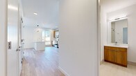 Located at 22 W Camden St in Hackensack, NJ, this single-floor residence offers a clean, contemporary design with a cohesive palette of white walls, light wood flooring, and warm wood cabinetry throughout. The open-concept kitchen is outfitted with stainless steel appliances, a built-in microwave, and a peninsula with a white countertop that flows seamlessly into the living area. Recessed lighting illuminates the space, complementing the natural light that pours in through large street-facing windows, which offer views of the surrounding Hackensack neighborhood. A dedicated living area provides ample room and features a wall-mounted PTAC unit for climate control. The bedroom is a serene, light-filled space with clean white walls and light wood flooring, offering a blank canvas for personalization. The bathroom is tastefully finished with large-format tile in the tub surround, a warm wood vanity with a white countertop, a wall-mounted mirror with integrated lighting, and polished chrome fixtures. Throughout the unit, the consistent use of natural tones and modern materials creates a cohesive, contemporary ambiance suited for comfortable urban living in the heart of Hackensack.
