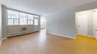 Located at 1231 Richmond St in London, Ontario, this single-floor, 3-bedroom, 1-bathroom unit offers a practical and well-organized layout. Light wood-style flooring runs consistently throughout the space, lending a clean and cohesive aesthetic to every room.

The living room is a bright, open area featuring large windows that invite generous natural light and offer views of the surrounding urban streetscape. Baseboard heating runs beneath the windows, and the room provides ample space for comfortable furnishings.

The galley-style kitchen is efficiently designed with crisp white cabinetry, a subway tile backsplash, grey countertops, and stainless steel appliances including a refrigerator, electric range, and built-in microwave. The layout maximizes functionality within the corridor-style space.

All three bedrooms are well-proportioned with neutral grey walls, large windows with outdoor views, and baseboard heating. The primary bedroom includes a sliding-door closet, offering practical storage. The additional bedrooms also benefit from abundant natural light.

The bathroom features a clean, white-tiled tub and shower surround with chrome fixtures, maintaining the unit's consistent, neutral aesthetic. Two hallways connect the rooms efficiently, completing this functional and bright single-floor residence.