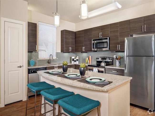 Kitchen with granite countertops, stainless steel appliances, wood-style floors, and modern lighting over island - Thirty Oaks